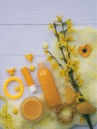 Set of yellow accessories for young girl or teenager. Nail polishes, lipstick, hair clips, bands, beads, bracelet, perfume and flowers. Spring beauty still life. Copy space. Top view.の写真素材