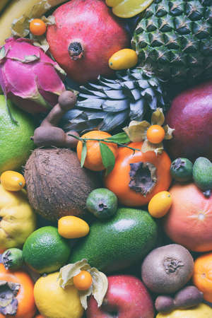 Mix of ripe tropical fruits with avocado, mango, kumquat, kiwi, citrus. Superfood background. Vegetarian raw food. Copy spaceの写真素材