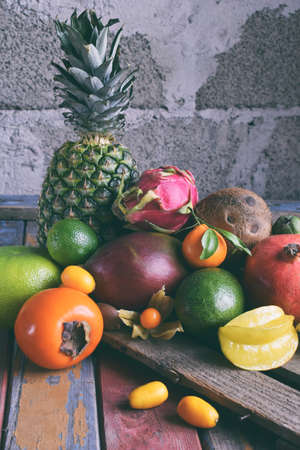 Mix of ripe tropical fruits with avocado, mango, kumquat, kiwi, citrus. Superfood background. Vegetarian raw food. Copy spaceの写真素材