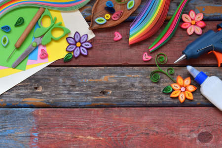 Quilling technique. Paper strips, flowers, scissors, elements. Handmade crafts on holiday theme:...