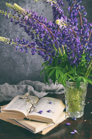 Lupine and old book. Still life with purple flowers bouquet in vaseの写真素材