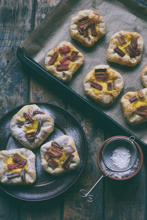 Mini pies made of puff pastry, custard and caramelized rhubarb. Homemade baking. Delicious freshly...