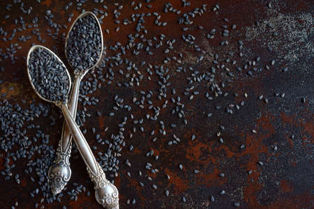 Black sesame seeds on dark concrete background. Close-up shot. Copy space.の写真素材