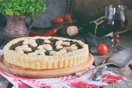 Homemade pie with mushrooms and herbs. Quiche on wooden background. Vegetarian food