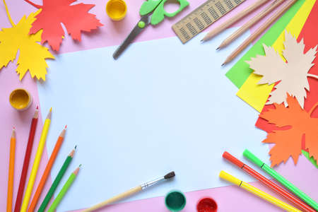School accessories and supplies: pencils, paint, ruler, paper maple leaf, scissors on a light background. Back to school concept. Hello Autumn. Handmade crafts. Children's DIY. Flat lay. Copy space.の写真素材