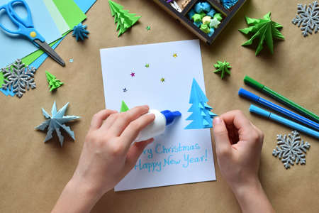 Making greeting card with origami 3D Xmas tree from paper. Merry Christmas and Happy New Year...