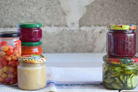 Variety of preserved food in glass jars - pickles, jam, marmalade, sauces, ketchup. Preserving...