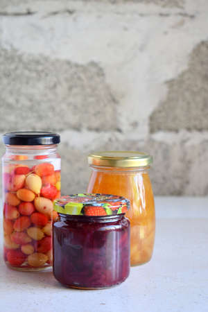 Variety of preserved food in glass jars - pickles, jam, marmalade, sauces, ketchup. Preserving...