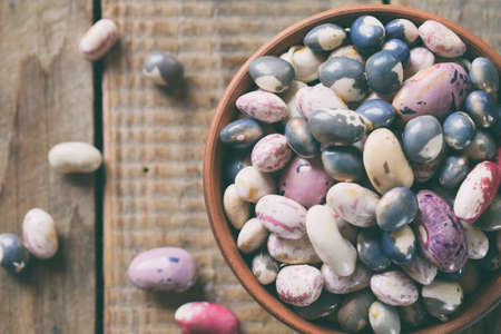 Assortment of young legumes and beans of different varieties and colors in a clay bowl. Raw food....
