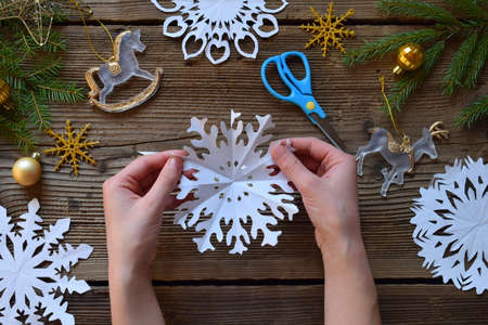 Making paper snowflakes with your own hands. Children's DIY. Merry Christmas and New Year conceptの写真素材