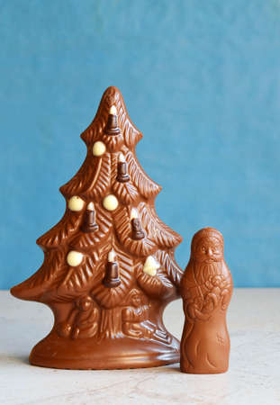 Chocolate Christmas tree and Santa Claus on blue background. Happy New Year and Merry Christmas concept. Copy space.の写真素材