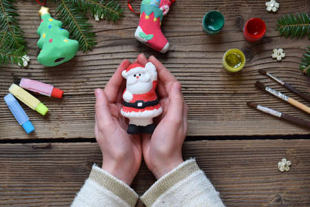 Painting Christmas toys from porcelain for decorations. Making clay toy with your own hands. Children's DIY concept. Handmade crafts on holiday. Master class of art.の写真素材
