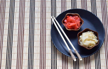Pickled ginger slices and wooden chopsticks. Ingredient for sushi. Healthy food. Traditional Japanese condiment.の写真素材