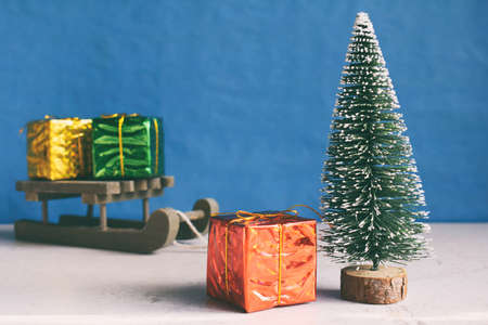 Faux Christmas tree and gifts on little sleigh. Happy New Year and Merry Christmas concept.Greeting card or festive background. Copy space.の写真素材