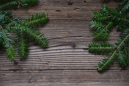 The branches of spruce on a wooden background. Happy New Year and Merry Christmas concept. Greeting card or festive background. Copy space.の写真素材