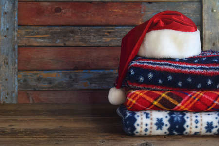 Christmas and New Year composition. Plaid, Santa Claus hat on wooden background. Winter Holiday...