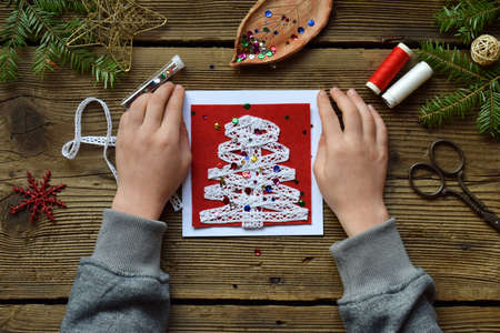 Making of handmade christmas greeting card from felt with your own hands. Children's DIY concept. Making xmas decoration.の写真素材