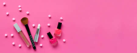 Nail polishes, lipstick on a pink background. Makeup cosmetics for young women or teenager. Copy space. Top view.の写真素材