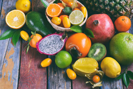 Mix of ripe tropical fruit with avocado, mango, coconut, carambola, banana, kumquat, pitahaya, kiwi Superfood background Vegetarian foodの写真素材
