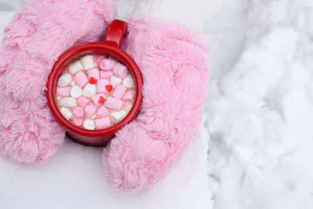 Woman Hands Holding Cup of Hot Chocolate with Marshmallow candies. Fur mittens and Warm cocoa drink. Hello February or Valentines Day concept.の写真素材
