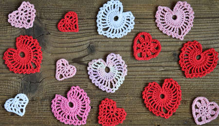 Crochet openwork hearts on wooden background. Valentines Day greeting card concept. Valentine Day craftsの写真素材