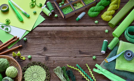 Green accessories for needlework on wooden background. Knitting, crochet, embroidery, sewing. Small business. Income from hobby. DIY Handmadeの写真素材