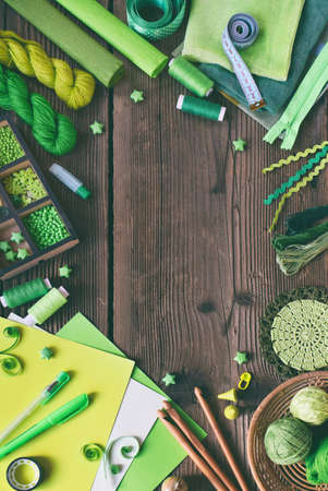 Green accessories for needlework on wooden background. Knitting, crochet, embroidery, sewing. Small business. Income from hobby. DIY Handmadeの写真素材