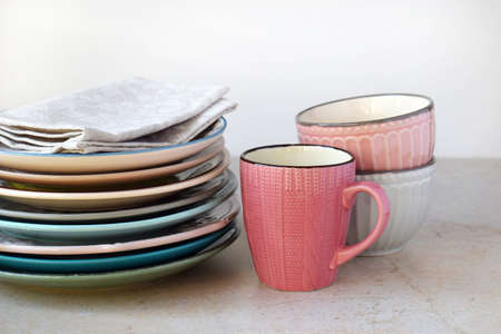 Multicolored empty ceramic plates, mugs and bowls on a marble background. Table setting. Shabby chic or retro style. Copy space. Mock up, concept for restaurant, menu.の写真素材