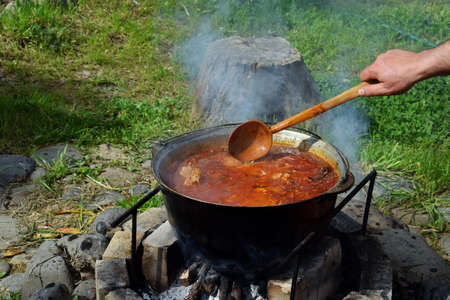 Bograch. Soup with paprika, meat, bean, vegetable, dumpling. Traditional Hungarian Goulash in cauldron. Meal cooked outdoors on an open fire. Delicious and healthy food popular in Central Europe.の写真素材