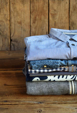 Teenager casual outfit. Boys shoes, clothing and accessories on wooden background - sweater, shirt. Top view. Flat lay.の写真素材