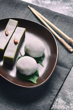 Mix of Traditional Japanese sweets - daifuku mochi sweet paste anko wrapped around with soft rice mochi shell and jelly dessert yokan made of beans, agar, sugar and green tea matchaの写真素材