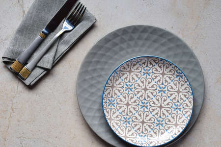 Multicolored empty ceramic plates and bowls on a marble background. Table setting. Shabby chic or retro style. Copy space. Mock up, concept for restaurant, menu.の写真素材