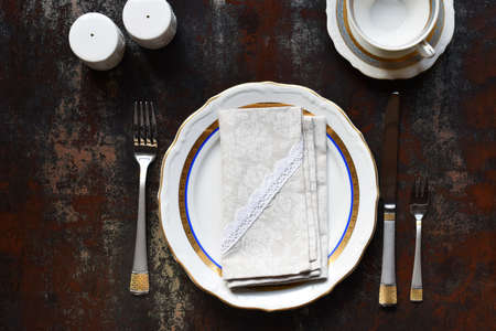 Empty ceramic plates and cutlery. The Tableware on dark background. Table setting. Copy space. Mock...