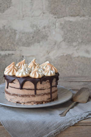 Piece of chocolate cake decorated with rosettes of meringue cream, chocolate-nut biscuit, caramel cream. homemade bakingの写真素材