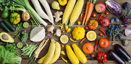 White, yellow, green, orange, red, purple fruits and vegetables on wooden background. Healthy food. Multicolored raw food.の写真素材