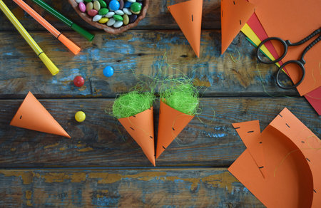 Carrots gift Bag for candies. DIY paper craft with your own hands together with children. Easter treat box. Art project for kids. Step by step guide.の写真素材