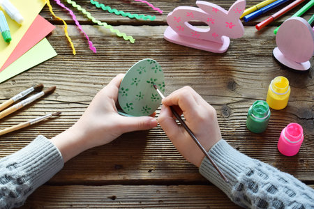 Making Easter decoration - easter eggs and bunny. Painting and coloring wooden toys of brushes and gouache. Creative process. Children's DIY concept.の写真素材