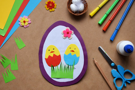 Making of handmade Easter decoration. Child made greeting card in egg shape. Childrens DIY concept, gift with your own hands. Hobby, paper crafts at home or in kindergarten.の写真素材