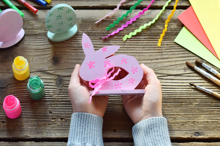 Making Easter decoration - easter eggs and bunny. Painting and coloring wooden toys of brushes and gouache. Creative process. Children's DIY concept.の写真素材