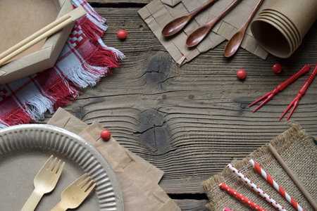 Natural Brown Eco Tableware Set on Vintage Wooden Background. Recyclable and Compostable Forks, Spoons, Paper Straws, and Cups for Environmentally Friendly Dining and Takeaway Useの写真素材