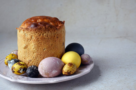 Traditional Easter Kulich with Colorful Painted Eggs on Ceramic Plate. Homemade Holiday Bread...