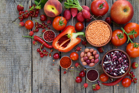Rustic assortment of fresh red vegetables lentils and berries on a wooden background perfect for organic food markets healthy eating promotions and natural culinary visualsの写真素材