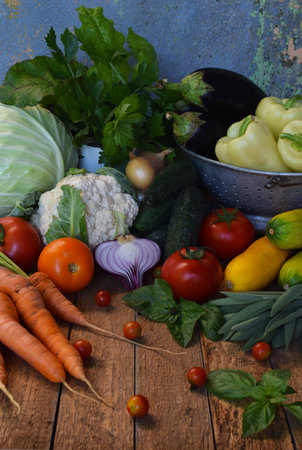Assortment of colorful fresh vegetables including cabbage carrots and tomatoes on a rustic background ideal for vegetarian recipes organic market visuals and healthy lifestyle promotionsの写真素材