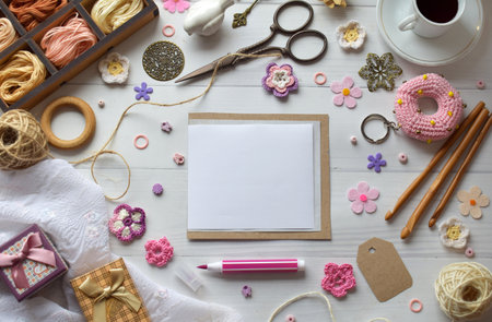 Handmade DIY workspace flat lay with yarn threads scissors crochet hooks and colorful accessories on a white wooden surface perfect for artisan craft and hobby projectsの写真素材