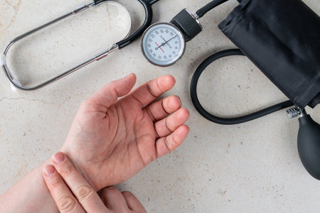 Doctor measuring blood pressure with tonometer and stethoscope on patient's hand. Healthcare and medical diagnosis concept showing blood pressure control, prevention and heart care at home or clinicの写真素材