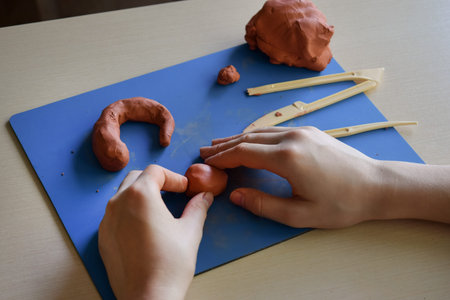 Kids clay sculpting master class flat lay step 2 shaping basic forms with hands creative educational activity fine motor skills development handmade craft processの写真素材