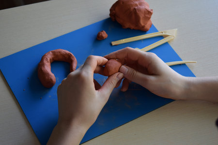 Children clay modeling flat lay step 3 forming small elements and details handmade creative craft educational learning fine motor skills development conceptの写真素材