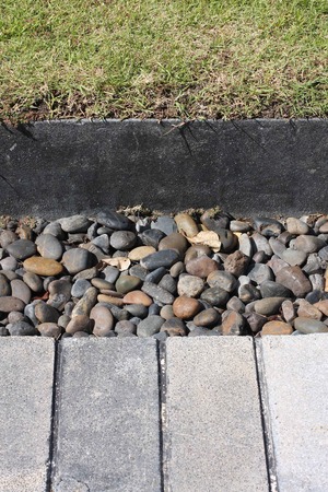 grass fieeld and the foot path and black stoneの写真素材