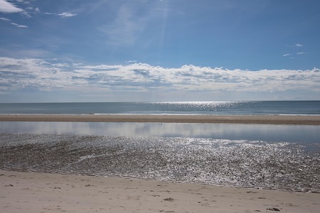 The beach and the sea have a reflection in the surfの写真素材