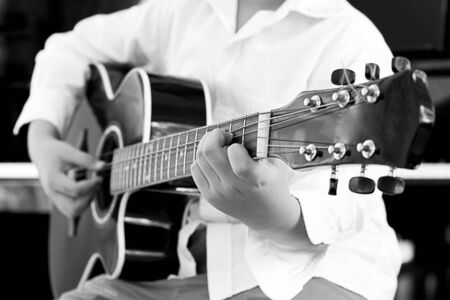 asian young boy learning to  play a Guitar